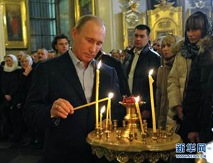 Путин зажигает свечу в храме